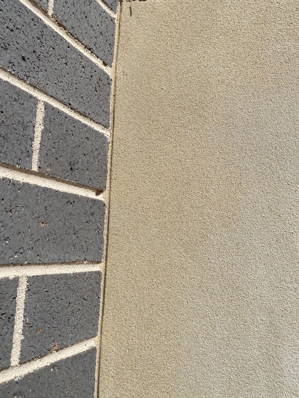 Render applied straight over a control joint, which will crack along that line, found during a fixing inspection in Gables